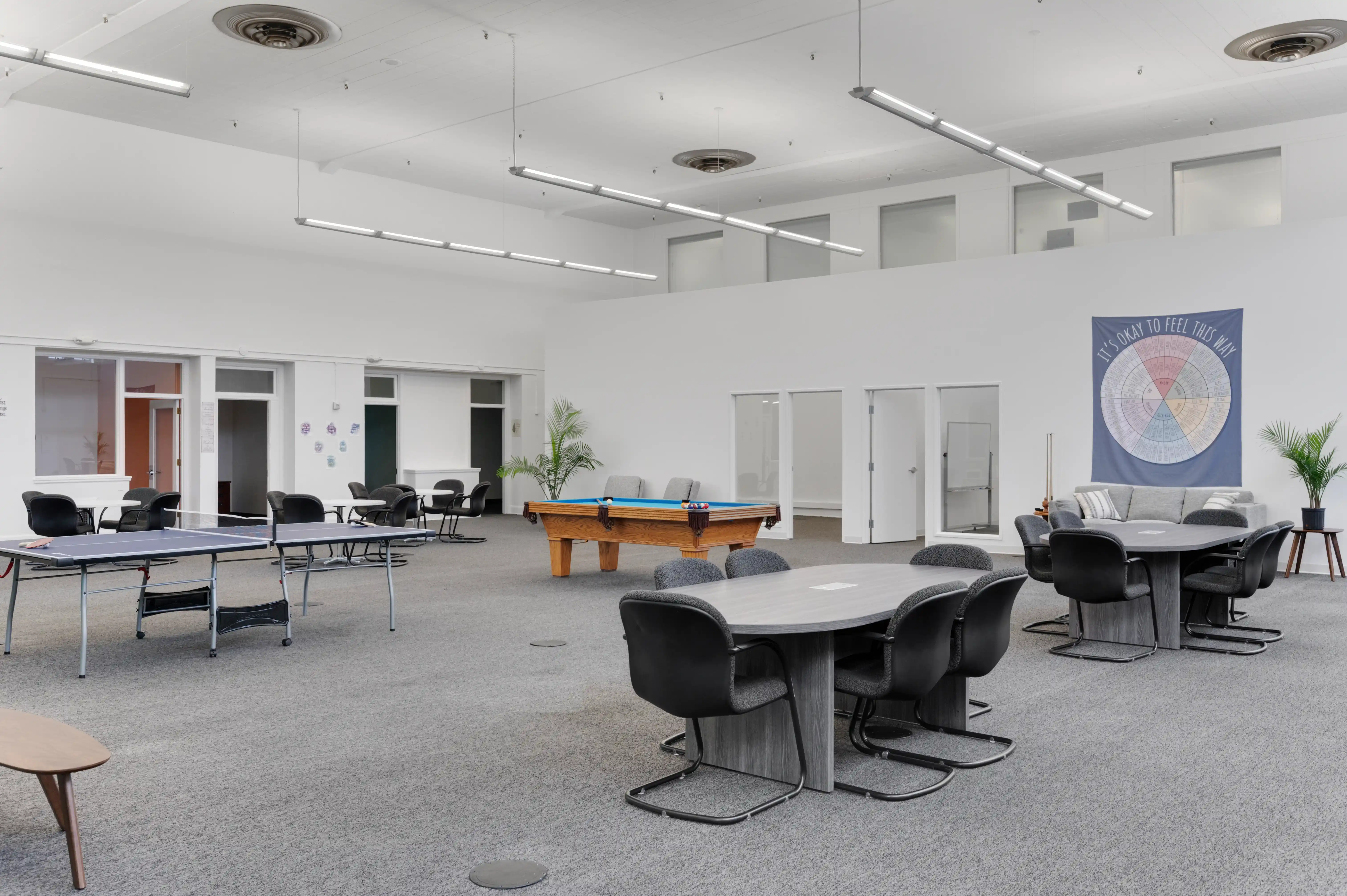 Community room with pool table, ping pong table, and group seating at Atlas Treatment Center