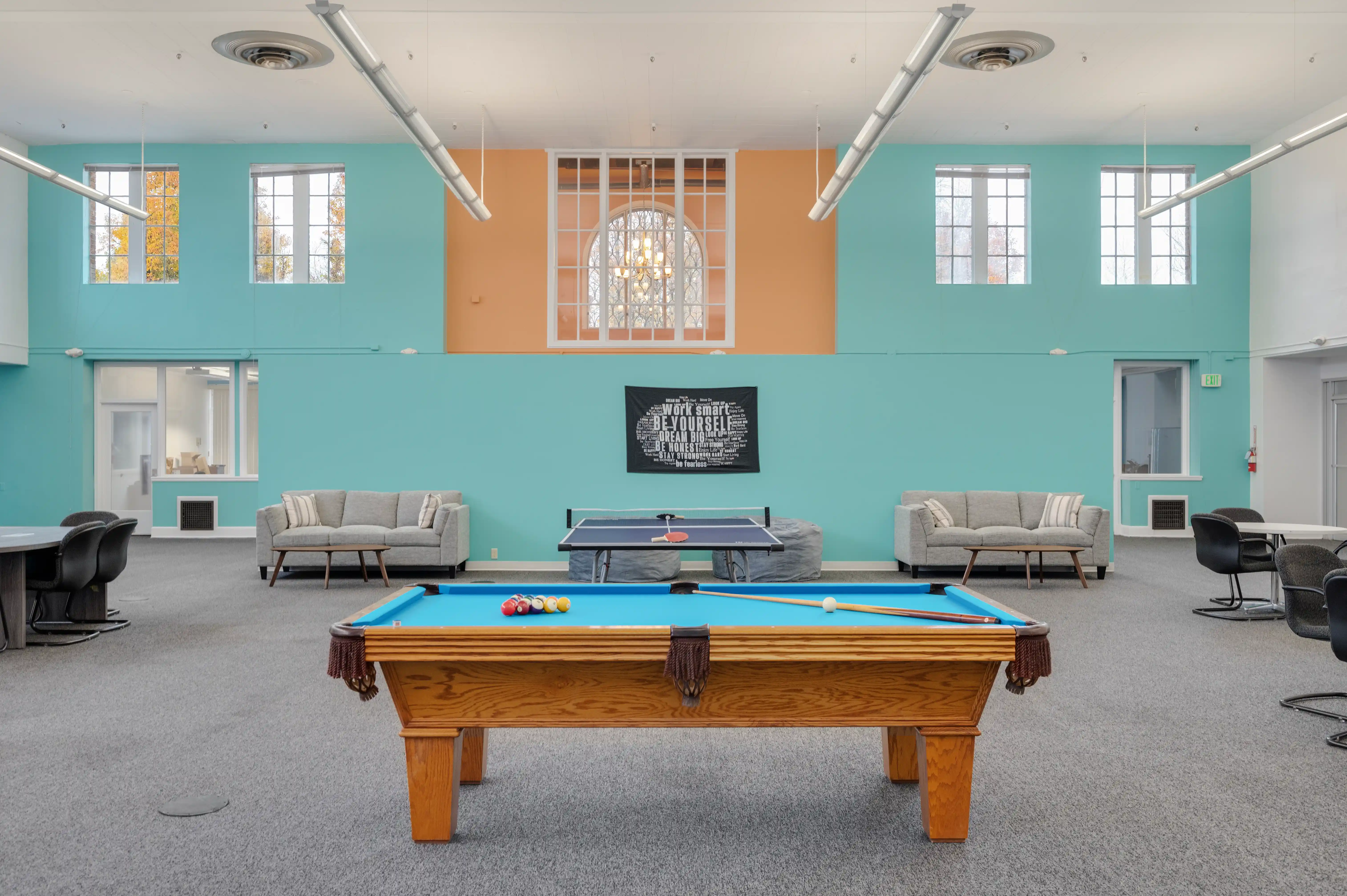 Bright recreation room with pool table and sofas at Atlas Treatment Center