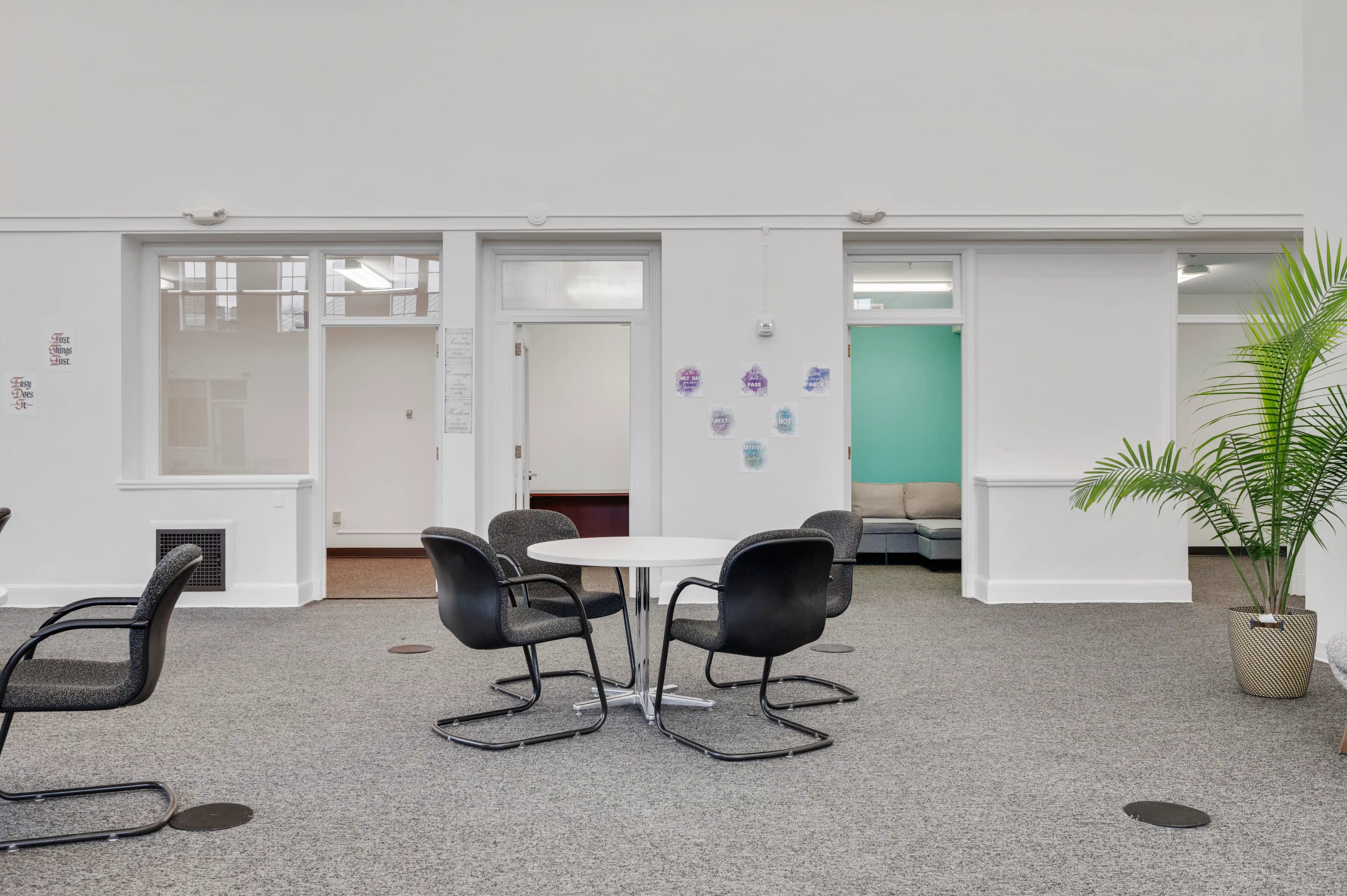 Common area with round table and chairs outside counseling rooms at Atlas Treatment Center