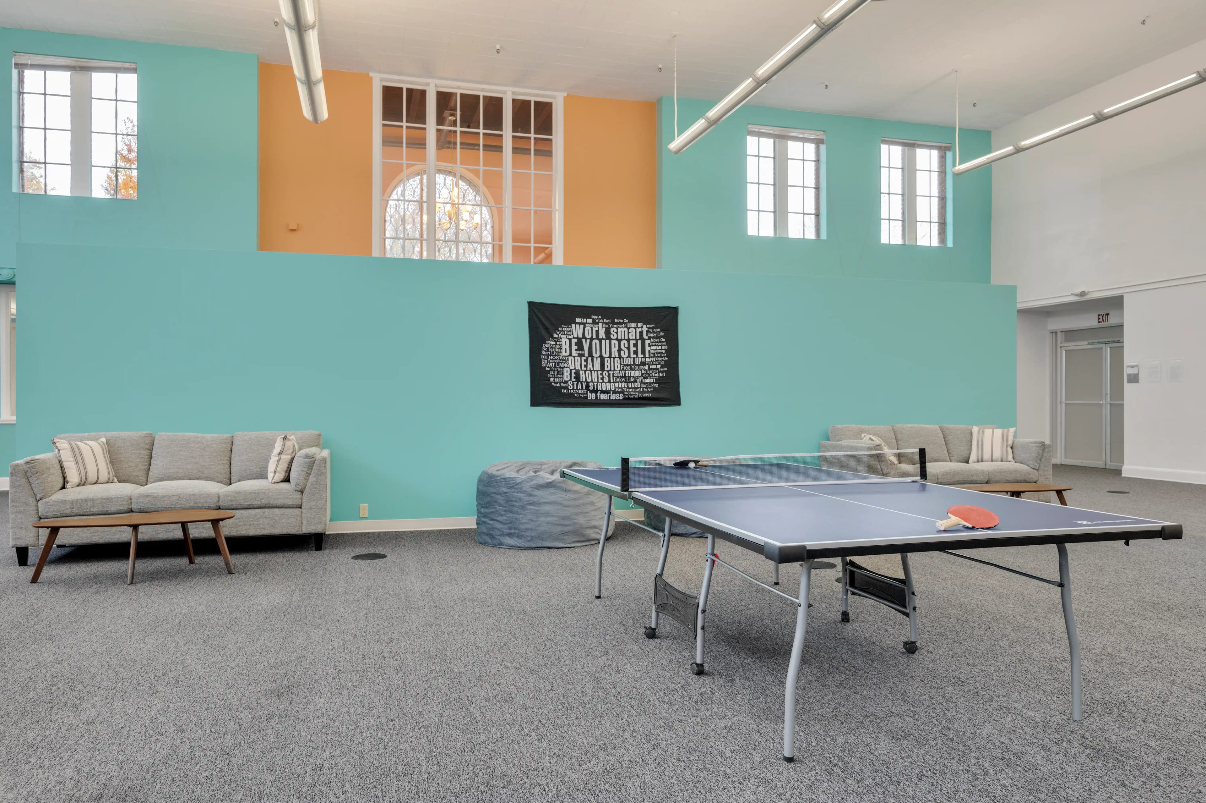 Recreation room with ping pong table and motivational banner at Atlas Treatment Center