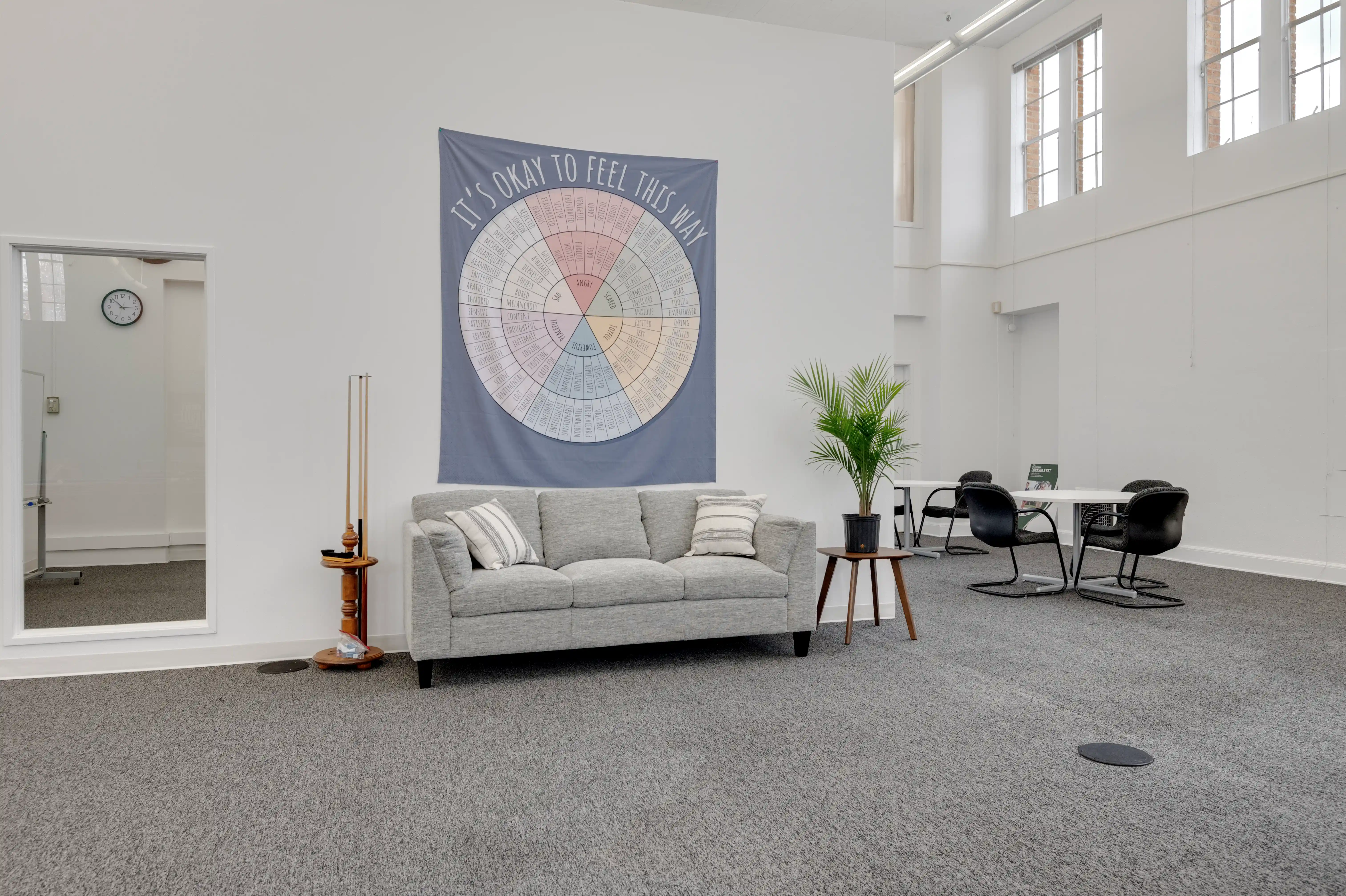 Lounge area with couch and "It's Okay to Feel This Way" emotions wheel at Atlas Treatment Center