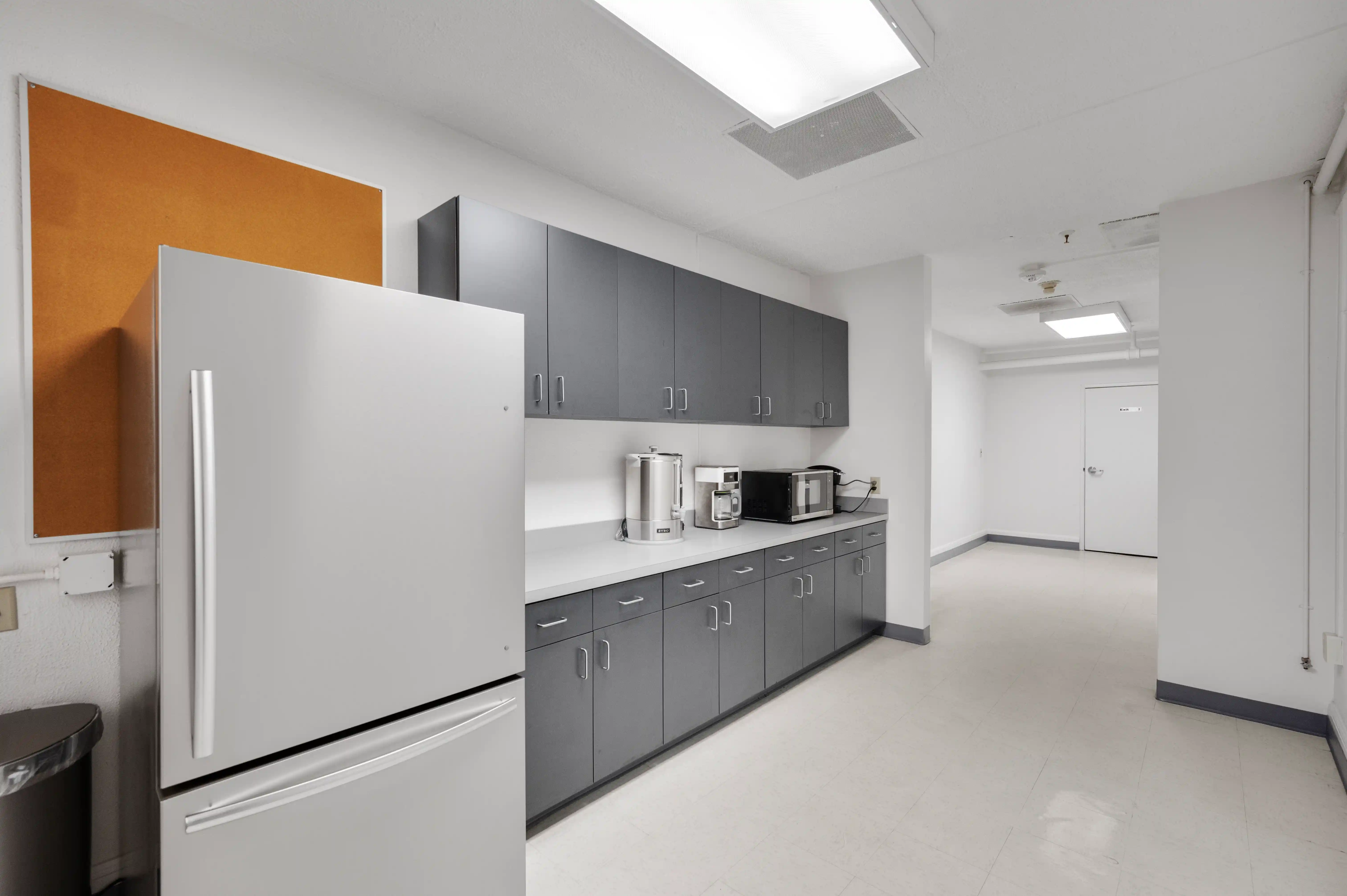 Client kitchen with refrigerator, cabinets, coffee maker, and microwave at Atlas Treatment Center