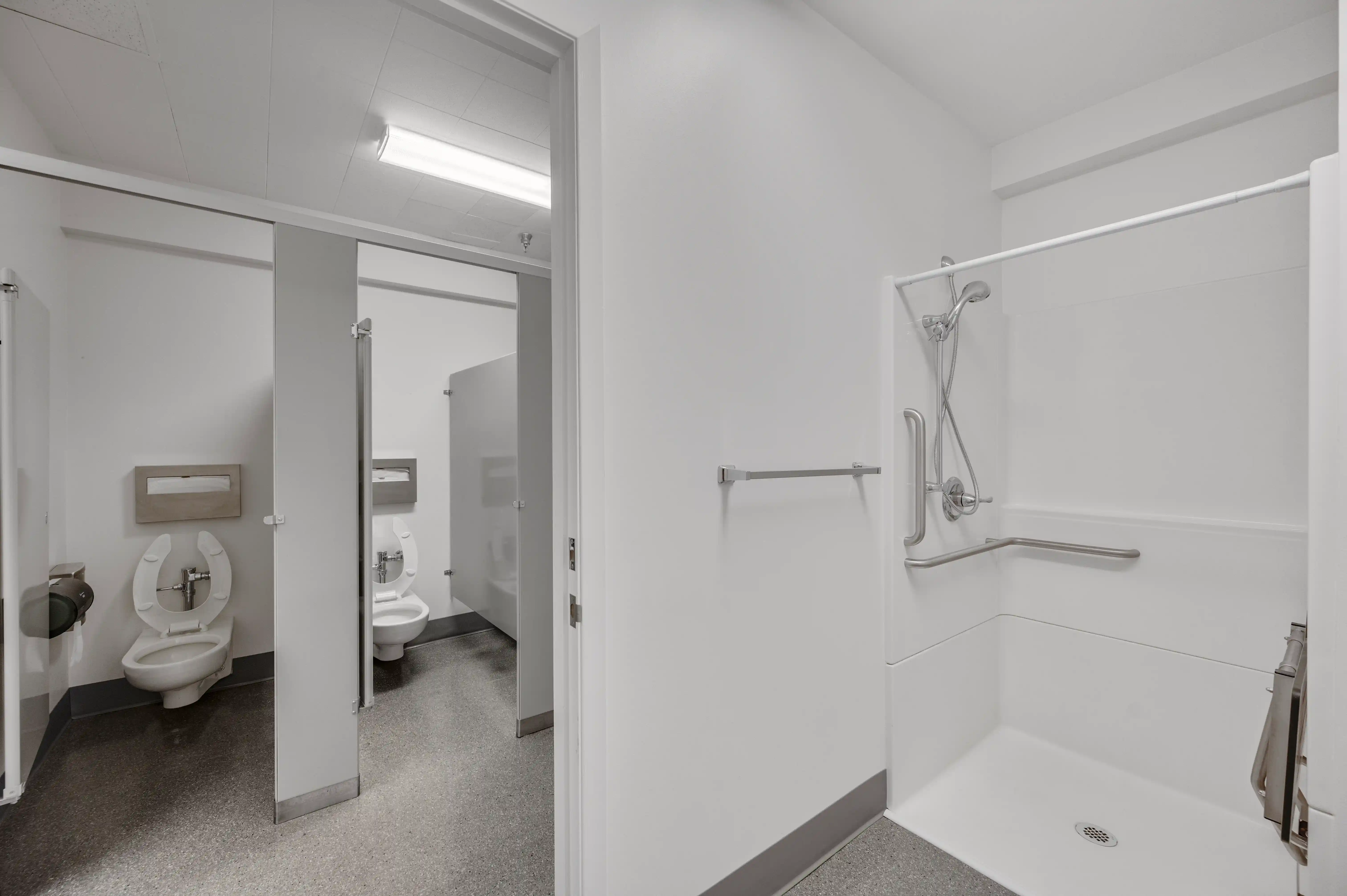 ADA-accessible bathroom with roll-in shower and grab bars at Atlas Treatment Center